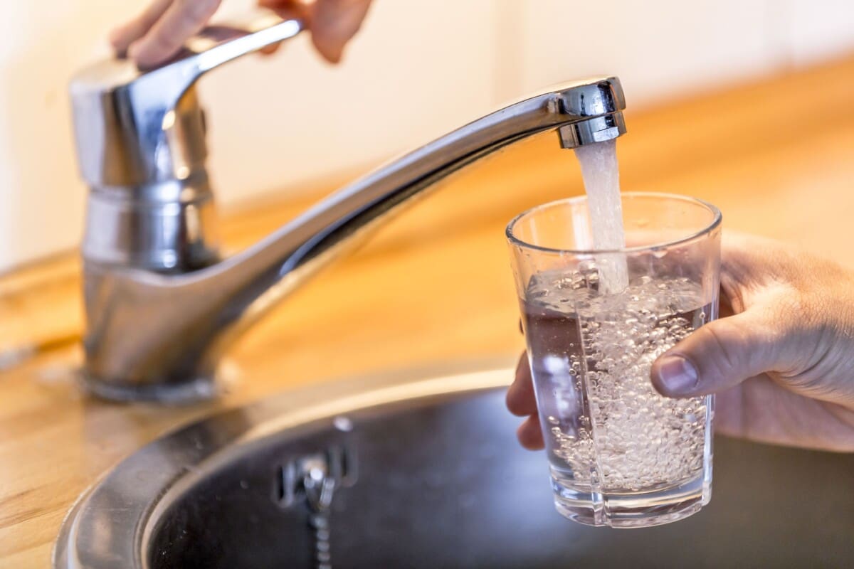 Filling up a cup with drinking water.
